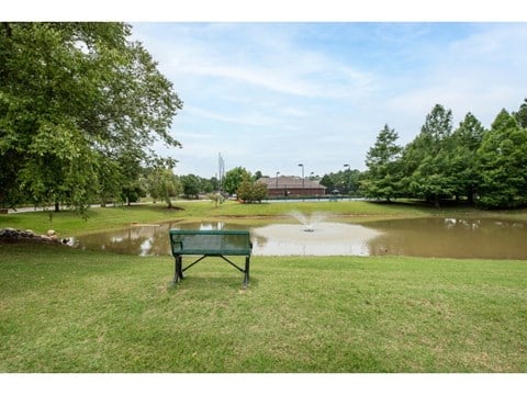 a park bench sits in front of a pond